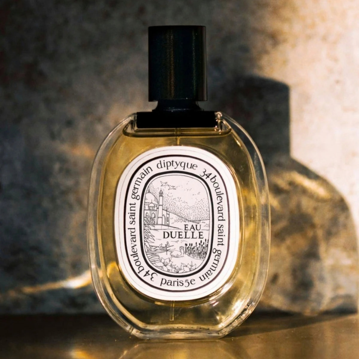 Front view of diptyque Paris Eau Duelle Eau de Toilette bottle showcasing oval label and black cap against warm background