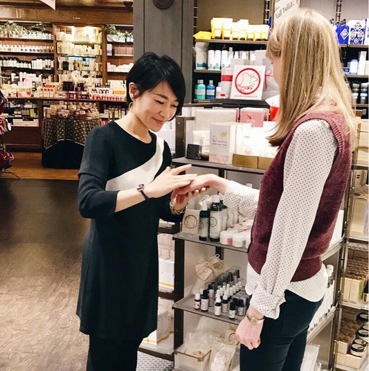 Mariko Sato talks with a woman beside personal care products in a Smallflower store