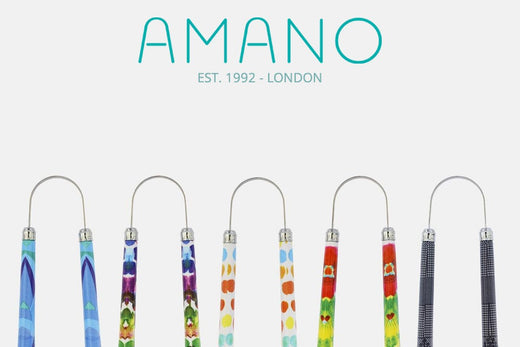 Front view of Amano tongue scrapers showcasing colorful patterned handles on a white background