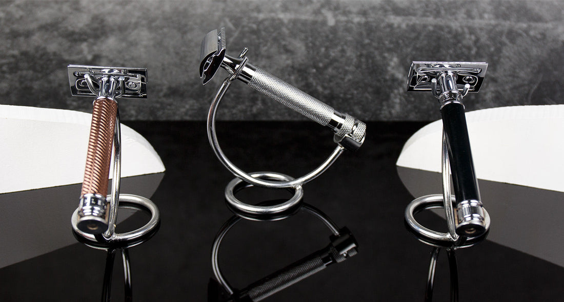 Three safety razors showcasing varied handle designs on a reflective black surface with a gray background