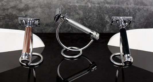 Three safety razors showcasing varied handle designs on a reflective black surface with a gray background