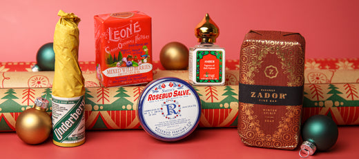 Assorted stocking stuffer gifts displayed in a festive holiday arrangement with ornaments and wrapped boxes