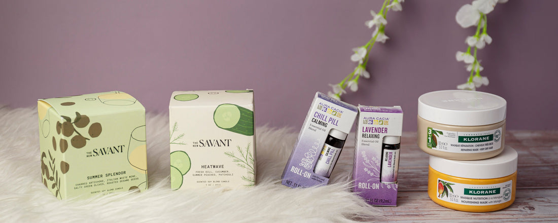 Staycation wellness products arranged on a white faux-fur rug and wooden table against a mauve background