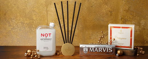 Wellness and personal care gift products arranged against a gold textured backdrop