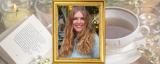 Portrait of Hannah Black in an ornate gold frame with a teacup, open book, and candles
