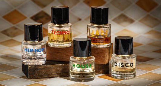 Five Zernell Gillie fragrance bottles labeled Hip-Hop, Techno, Jazz, House, and Disco on wooden blocks
