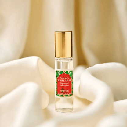 Front view of White Musk Fragrance Roll-On showcasing its gold cap and red-and-green label against white fabric