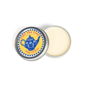 Top view of Swedish Dream Tiny Tea Time Lip Balm with illustrated tin label and open pale balm on white background