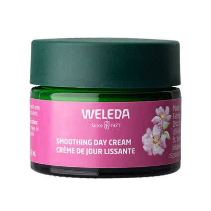 Front view of Weleda Smoothing Day Cream jar showcasing pink floral label and dark green lid on a white background