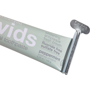 Angled view of Davids toothpaste tube key showcasing its metal grip on a toothpaste tube with a white background
