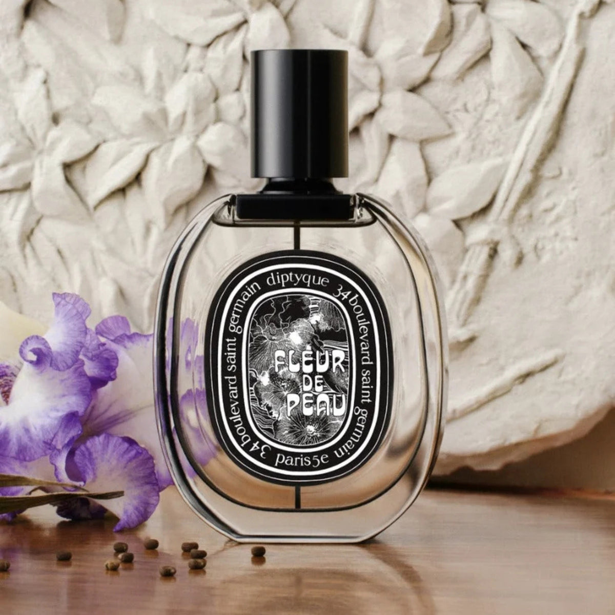 Front view of diptyque Paris Fleur de Peau Eau de Parfum bottle with black cap and purple flowers