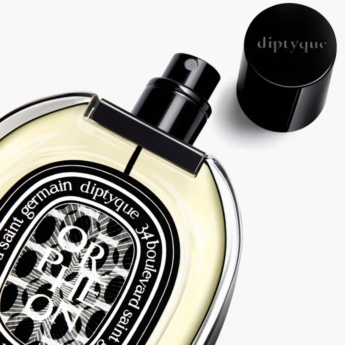 Close-up of diptyque Paris Orpheon Eau de Parfum 75 ml showcasing its round bottle, exposed sprayer, and black cap on white