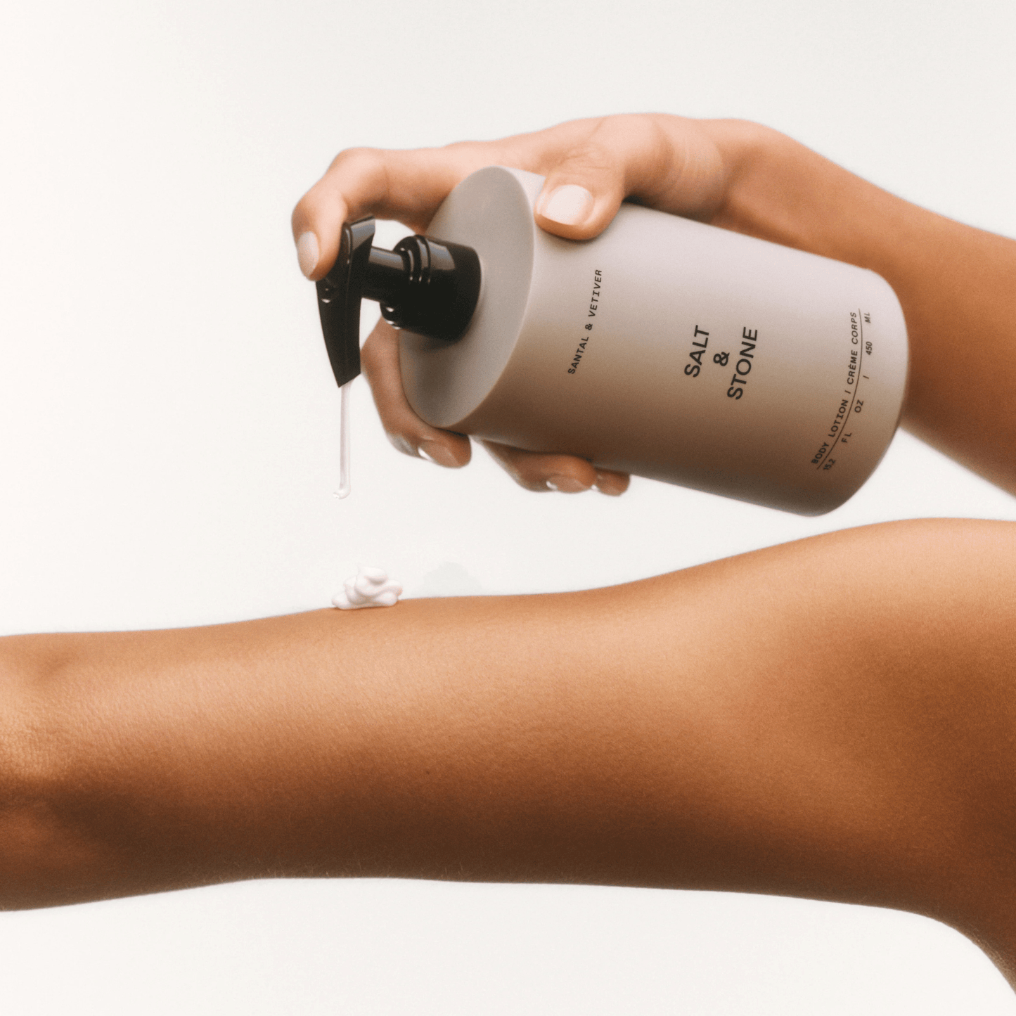 Alternate Image of Salt & Stone Body Lotion, round body lotion bottle with pump dispensing on skin