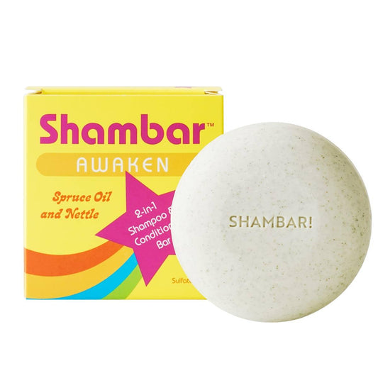 Front view of a round Shambar shampoo and conditioner bar beside colorful packaging on a white background
