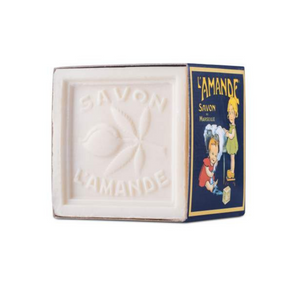 Three quarter view of L’amande Marseille Laundry Soap Cube showing embossed almond design and blue packaging on white